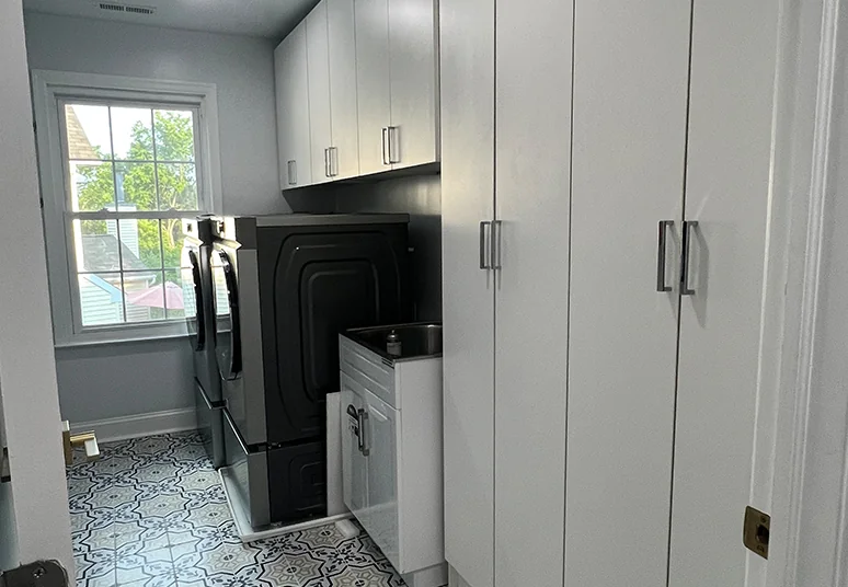 Laundry room with tall white cabinets, upper storage and a utility sink