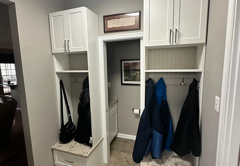 Mudroom with white upper cabinets, open cubbies and coat hooks
