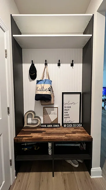 Compact entryway mudroom with hooks, shelf and a wood bench