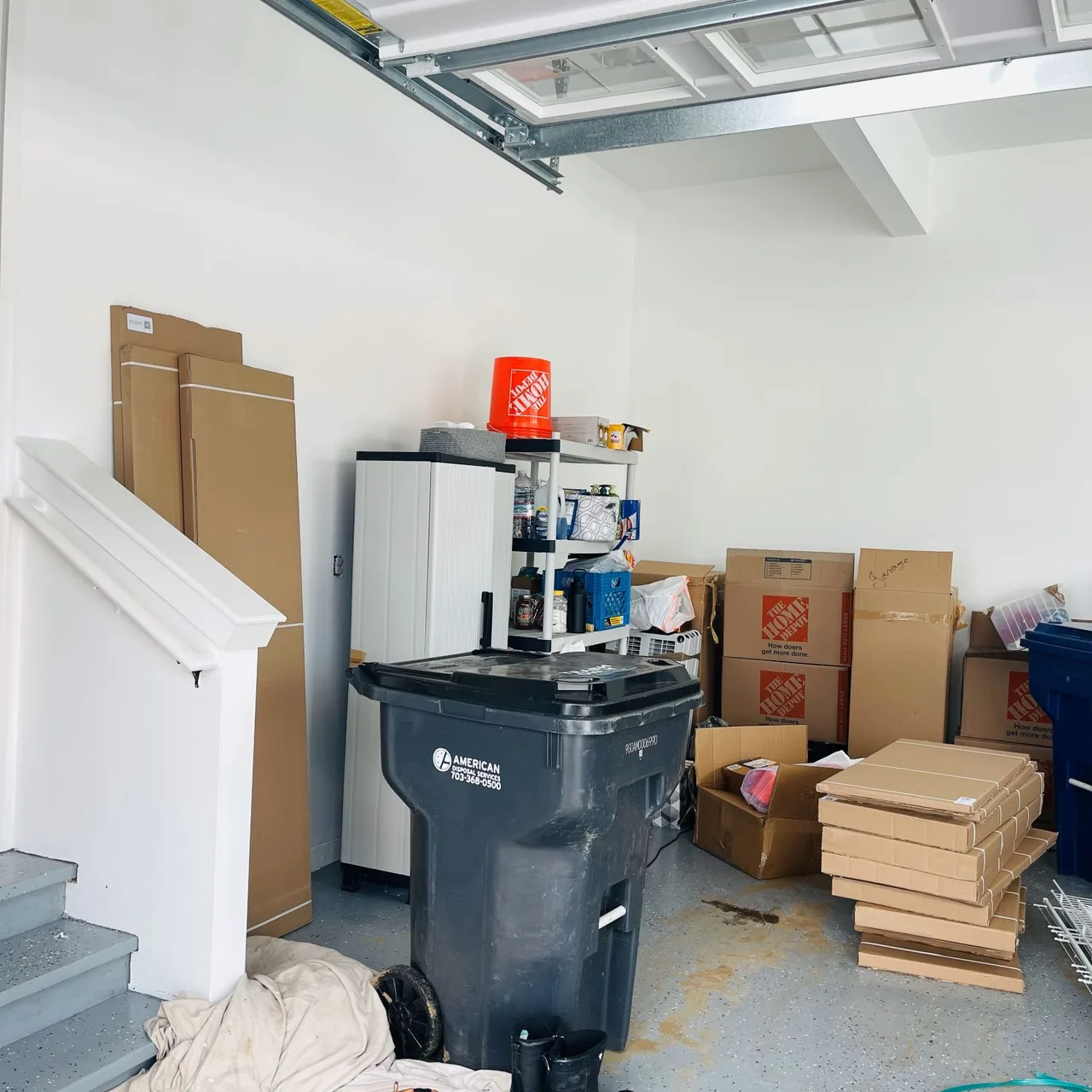 Cluttered garage with boxes and bins before the Up Closets makeover