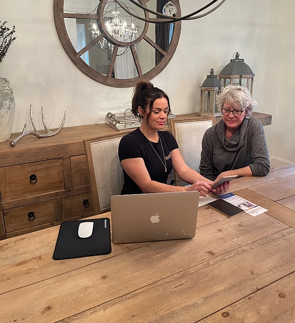Up Closets designer reviewing closet ideas with a homeowner at a dining table