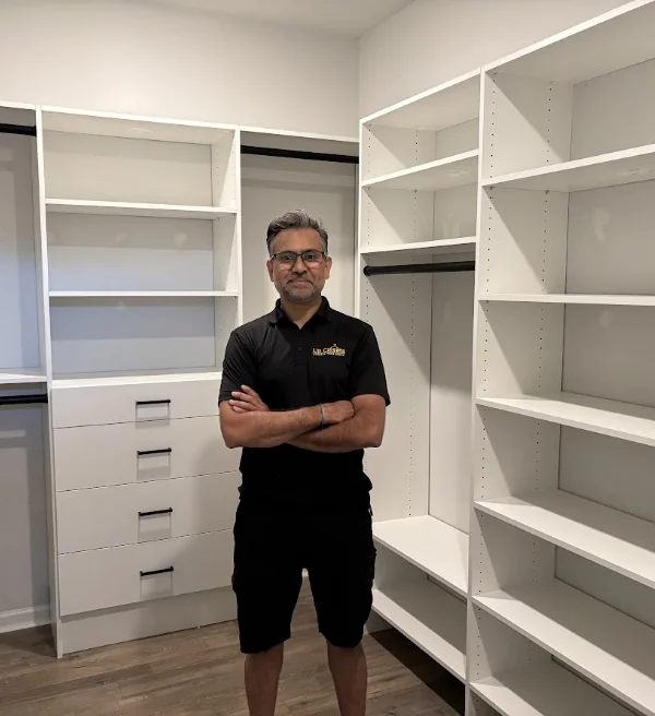 Up Closets installer standing in a newly installed white walk-in closet