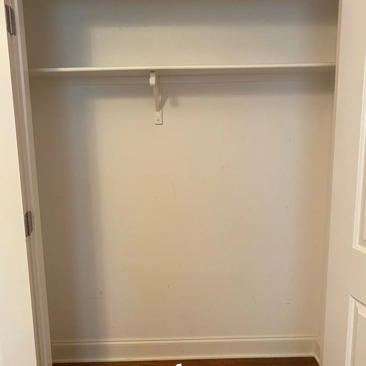 Empty reach-in closet with a single rod and shelf before the Up Closets makeover
